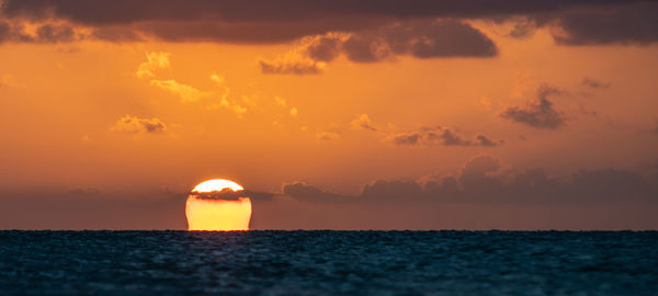 Scenic view of sea against romantic sky at sunset