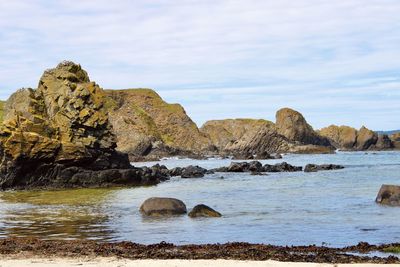 Rocks in sea against sky