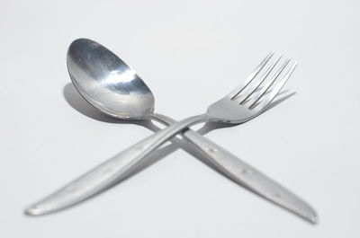 Close-up of spoon on table against white background
