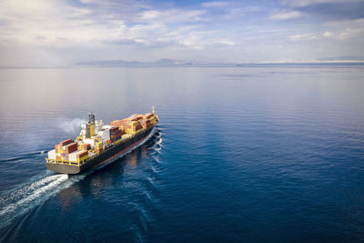 Ship sailing on sea against sky