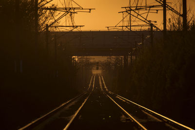 Railroad tracks against sky at sunset