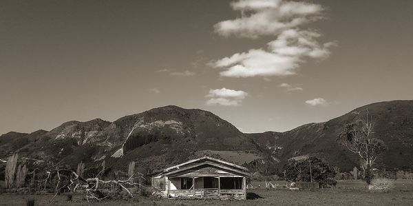 House by mountain against sky