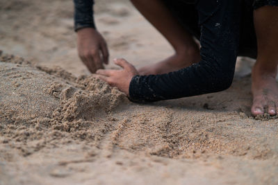 Low section of person on sand at beach