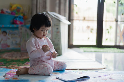 Cute girl sitting on floor at home