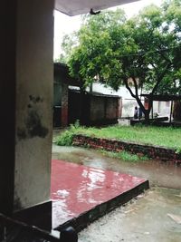 Wet footpath by buildings in city during rainy season