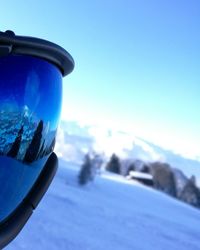 Close-up of car on snow against blue sky