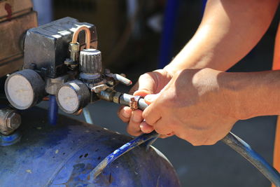 Cropped hands of worker adjusting equipment in workshop