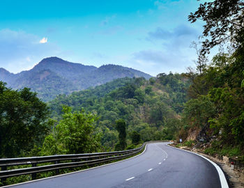 Road amidst trees against sky