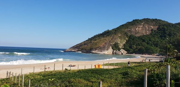 Scenic view of beach against clear blue sky