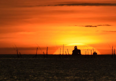 Silhouette sailboats on sea against sky during sunset