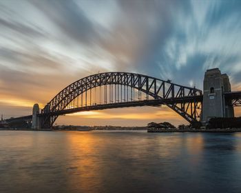 View of bridge over river against cloudy sky