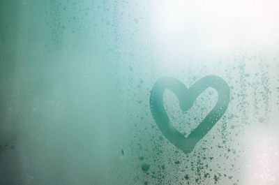 Close-up of heart shape on condensed window