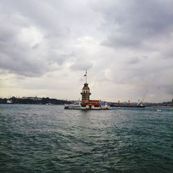 Ship in sea against cloudy sky