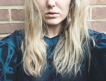 Cropped image of woman against brick wall