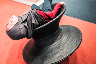High angle view of woman reclining on seat