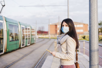 Full length of woman standing on train at railroad station