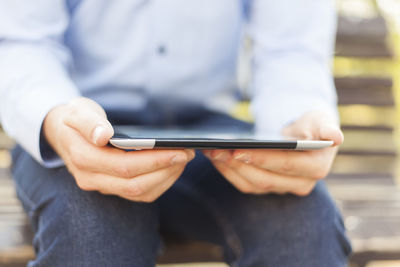 Midsection of man using mobile phone