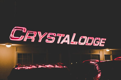 Low angle view of illuminated neon sign at night