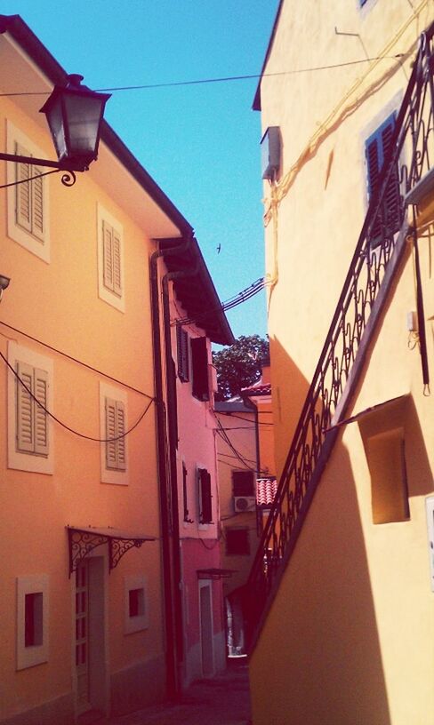 architecture, building exterior, built structure, residential building, residential structure, low angle view, clear sky, building, window, city, house, balcony, sunlight, outdoors, day, blue, sky, shadow, no people, town