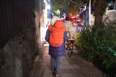 Rear view of man walking on street in city