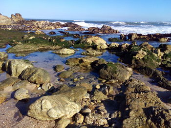 Rocks on beach against sky