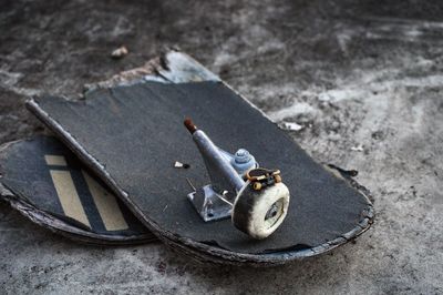 Close-up of broken skateboard on ground