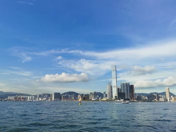 Sea by buildings against sky in city