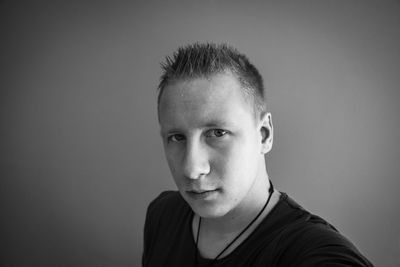Portrait of young man against gray background