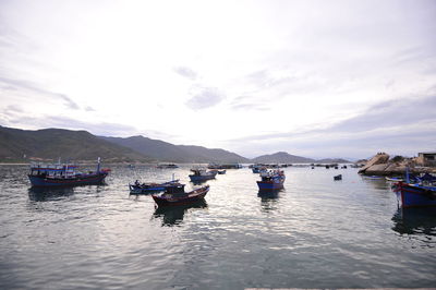 Boats moored in sea against sky