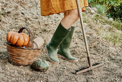 Woman dressed in linen dress and rubber boots work in the garden. life in countryside. cottagecore