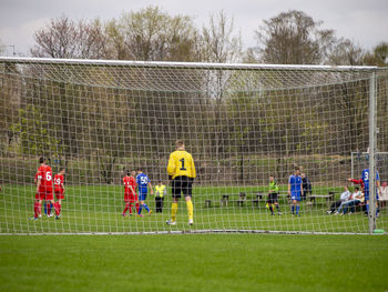 Group of people playing soccer on field