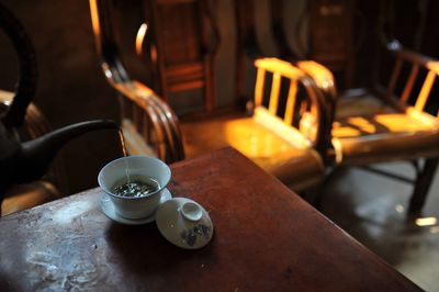 Cropped pot pouring tea in cup on table