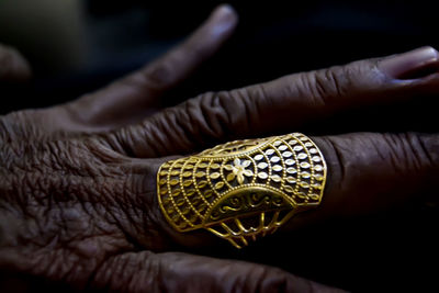 Close-up of man with wrinkled hand wearing ring