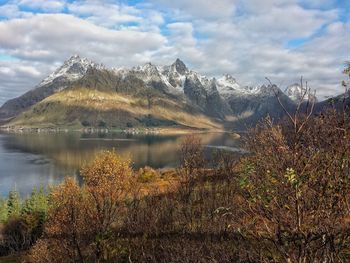 Scenic view of lake by mountains against sky