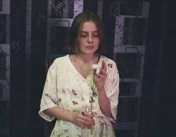 Woman in nightie looking at flower