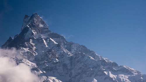 Low angle view of snowcapped mountain against sky