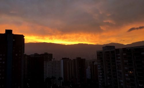Silhouette buildings against sky during sunset