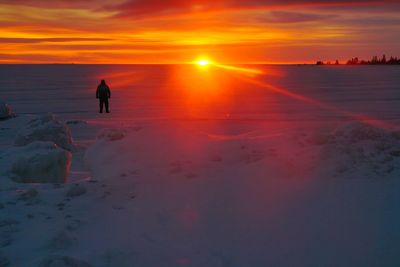 Scenic view of snow covered land during sunset