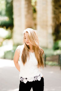 Young woman looking away while standing outdoors
