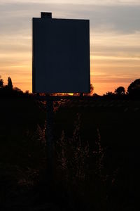 Silhouette field against sky during sunset