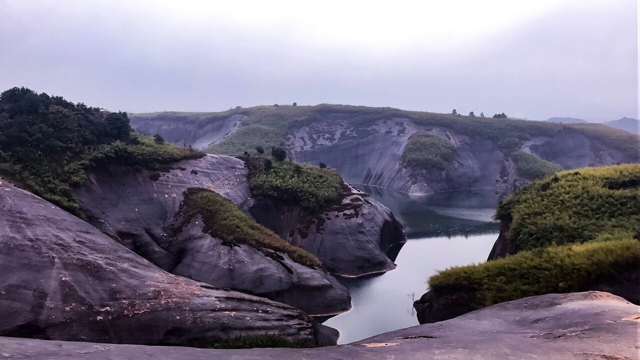 SCENIC VIEW OF WATERFALL AGAINST SKY