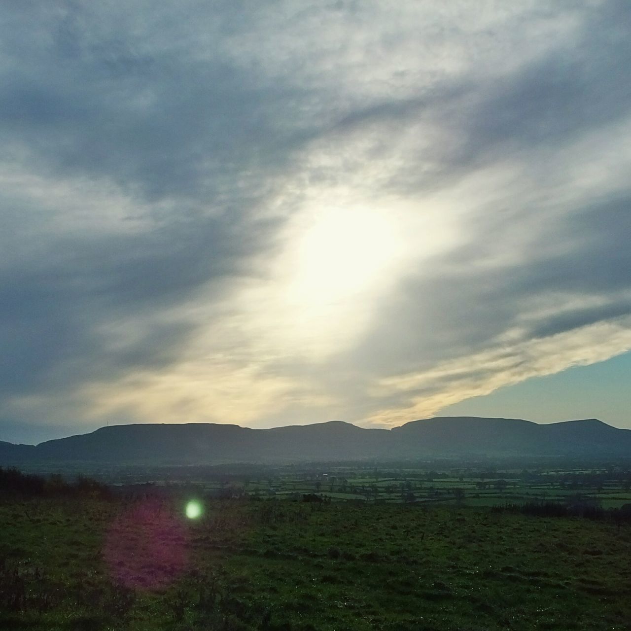 tranquil scene, sun, landscape, sky, mountain, tranquility, scenics, beauty in nature, cloud - sky, grass, nature, sunbeam, mountain range, field, sunlight, lens flare, idyllic, cloud, non-urban scene, cloudy