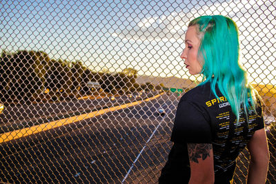 Woman standing next to chainlink fence