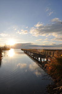 Bridge over river against sky during sunset