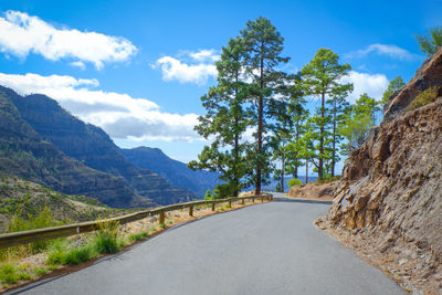 Road leading towards mountains against sky