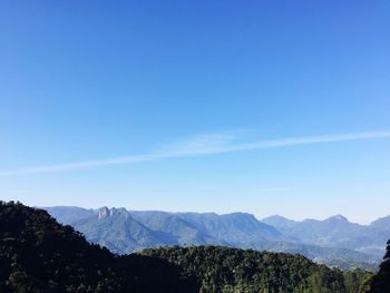 Scenic view of mountains against blue sky