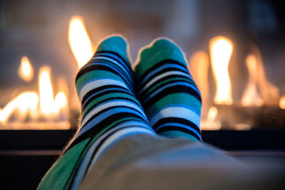 Low section of person wearing socks against fireplace at home