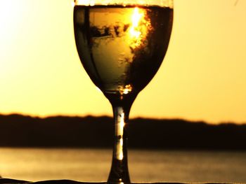 Close-up of beer in glass during sunset