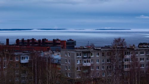 High angle view of buildings by sea against sky