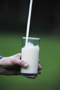 Close-up of hand holding drink with drinking glass